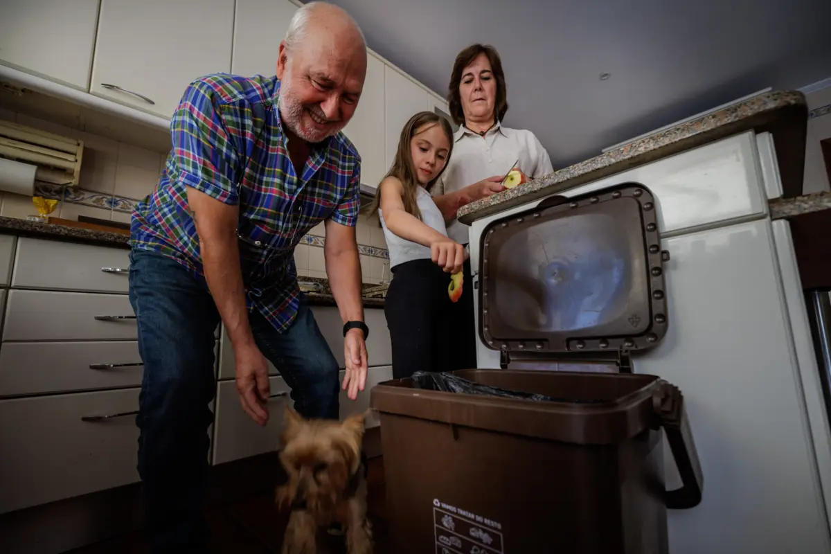 Helena e Carlos Veloso com a neta junto ao compostor