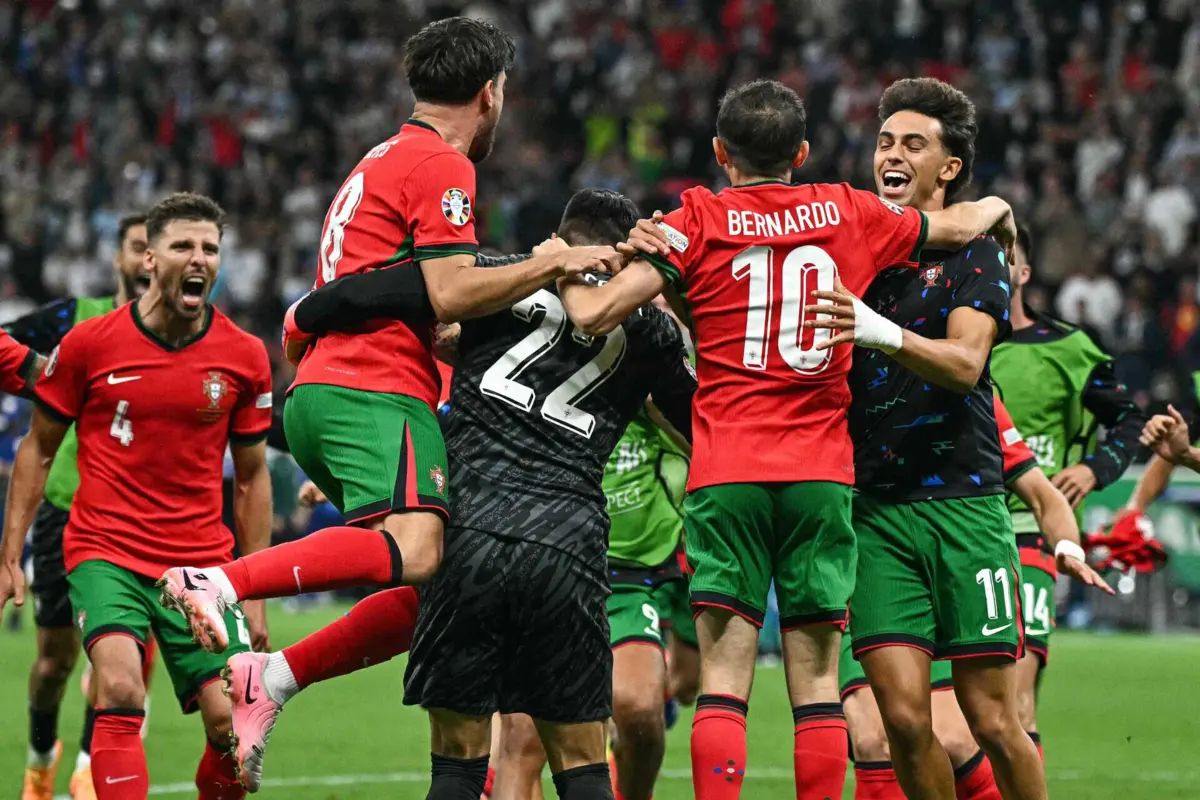 Jogadores portugueses celebram a passagem aos quartos junto do herói do jogo