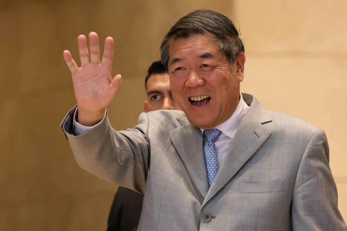 O vice-primeiro-ministro chinês, He Lifeng, acena à saída de um hotel durante as negociações comerciais entre os Estados Unidos e a China, em Kuala Lumpur