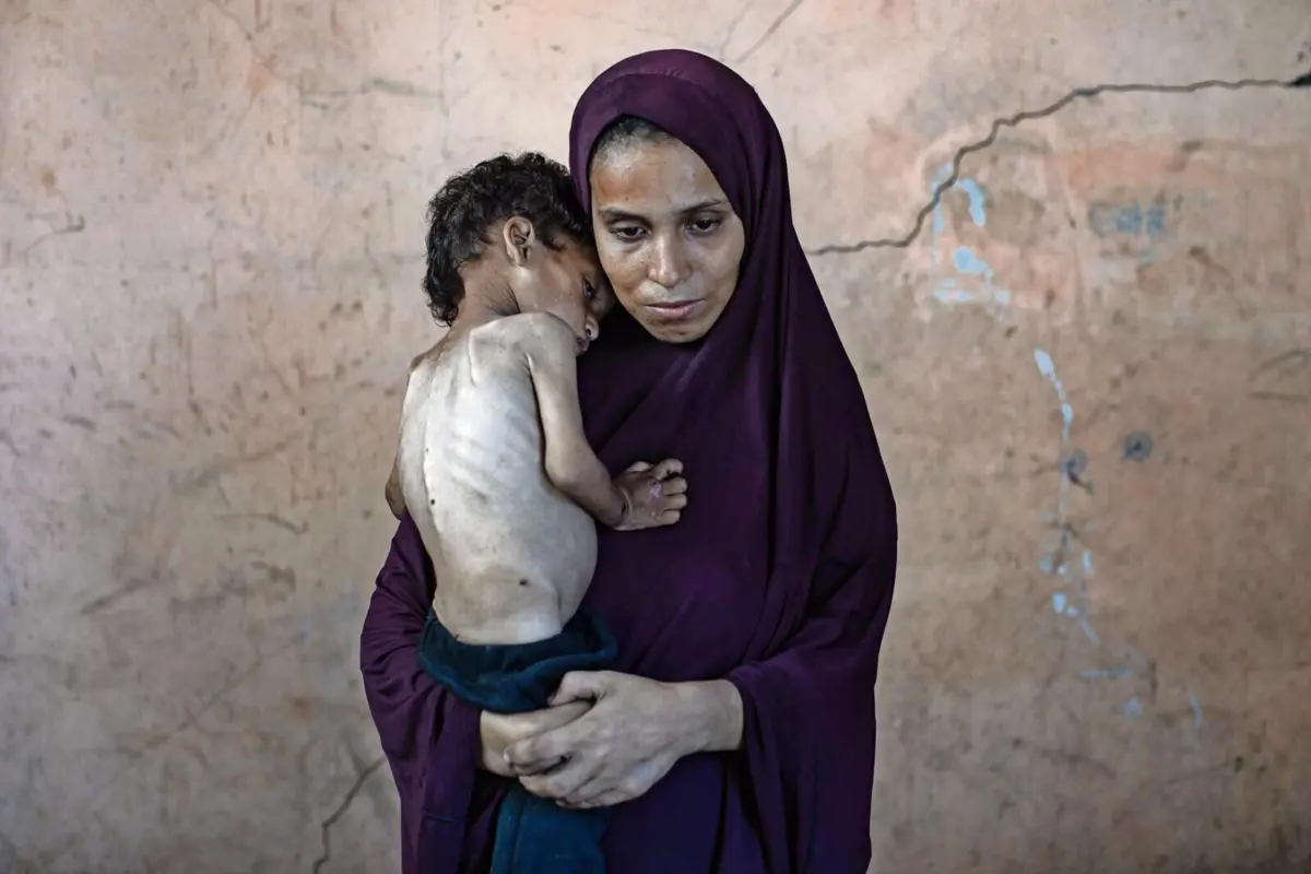 Yazan Abu Foul, de dois anos, no colo da mãe Naima, no campo de refugiados de Al-Shati