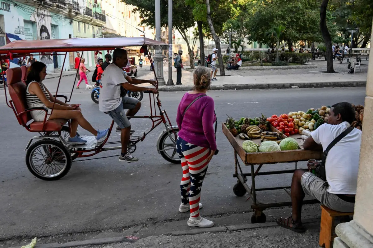 A woman wearing leggings with the US flag stands in the street in Havana on February 26, 2026. Cuba will defend itself with "determination" against any "terrorist aggression" targeting its sovereignty, President Miguel Diaz-Canel said on February 26, a day after an exchange of gunfire between the occupants of a boat registered in Florida and Cuban coast guards. (Photo by YAMIL LAGE / AFP)