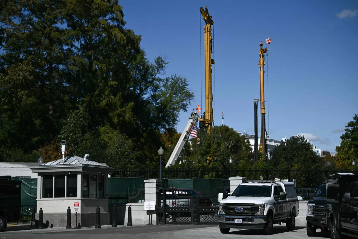 Equipamento de construção é visto para lá dos portões do complexo da Casa Branca, perto da Ala Leste da Casa Branca