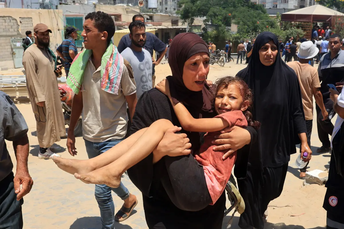 Mãe carrega a filha ferida para o Hospital Nasser, após o ataque