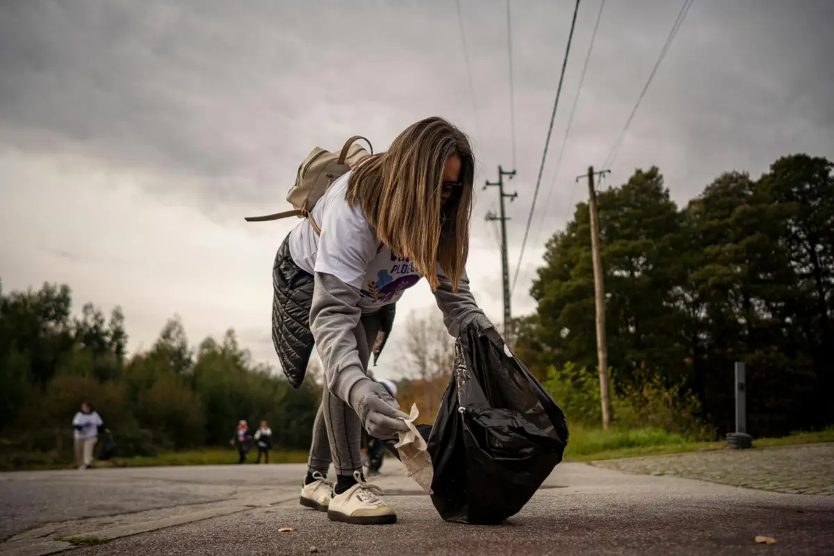 Participantes exercitam o corpo enquanto apanham lixo