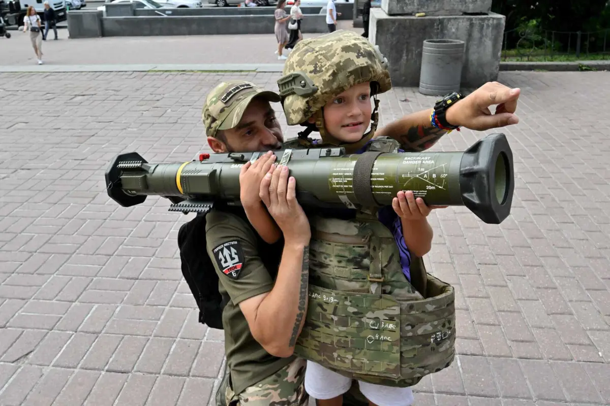 Soldado ucraniano mostr a uma criança um arma antitanque de fabrico sueco