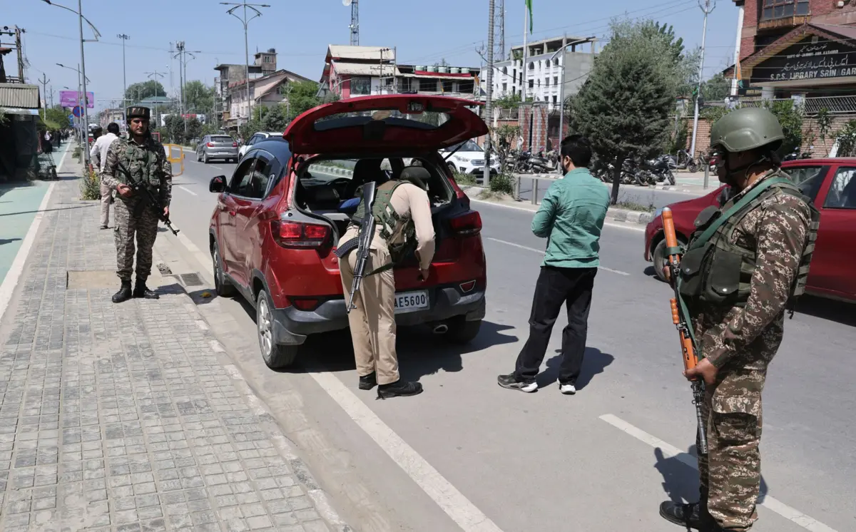 Exército paramilitar indiano protege polícia durante buscas na sequência de um ataque em Pahalgam, na região de Caxemira