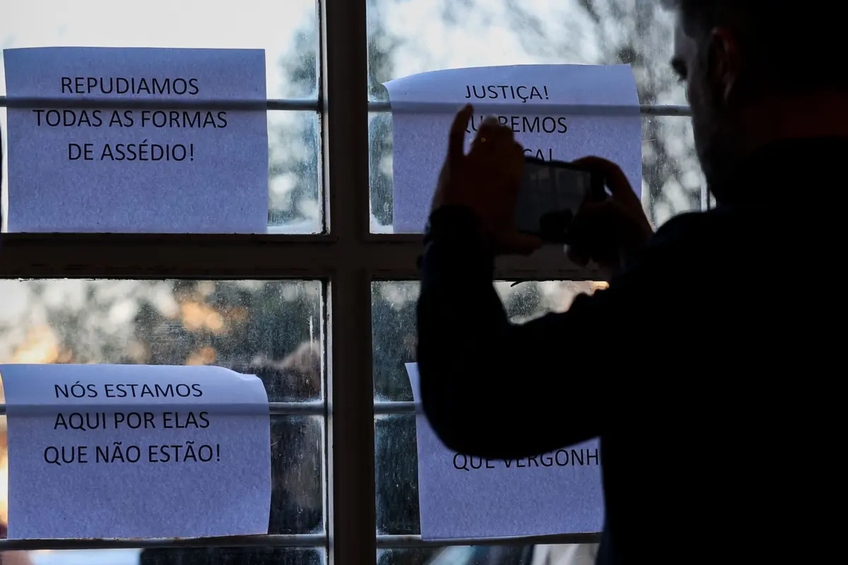 Alunas colocaram cartazes junto à sala onde estava a ser apresentado relatório da Comissão Independente