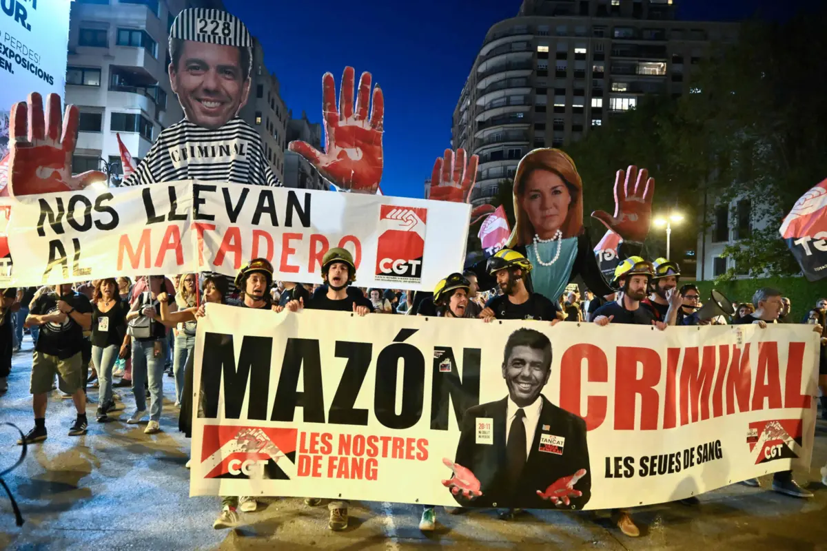 Manifestantes erguem faixas durante uma marcha para assinalar o primeiro aniversário das cheias mortais do ano passado e exigir responsabilização em Valência