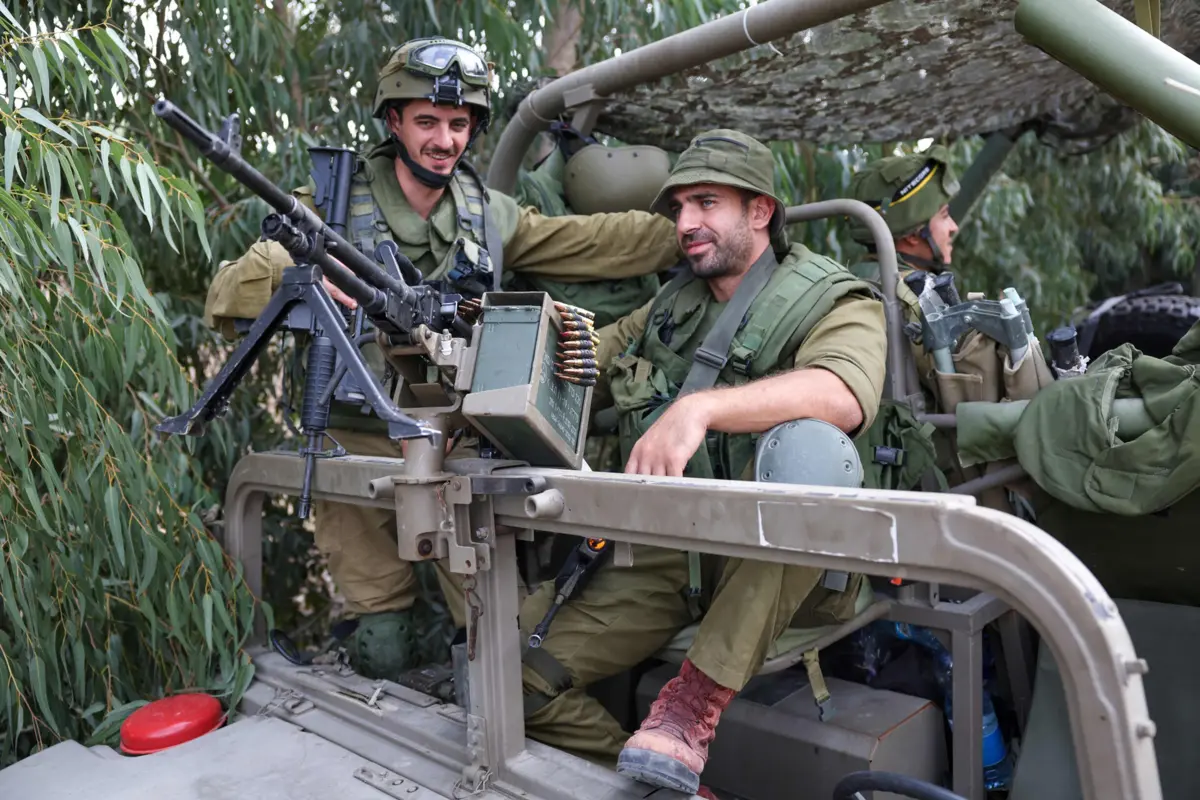 Soldados israelitas posicionados perto de uma estrada em Kfar Aza, ao Sul de Israel, na fronteira com a Faixa de Gaza