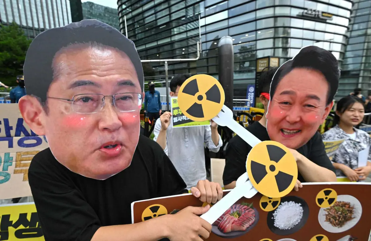 Ativistas sul-coreanos usam máscaras do primeiro-ministro japonês, Fumio Kishida (E), e do presidente da Coreia do Sul, Yoon Suk Yeol , durante um protesto contra o nuclear