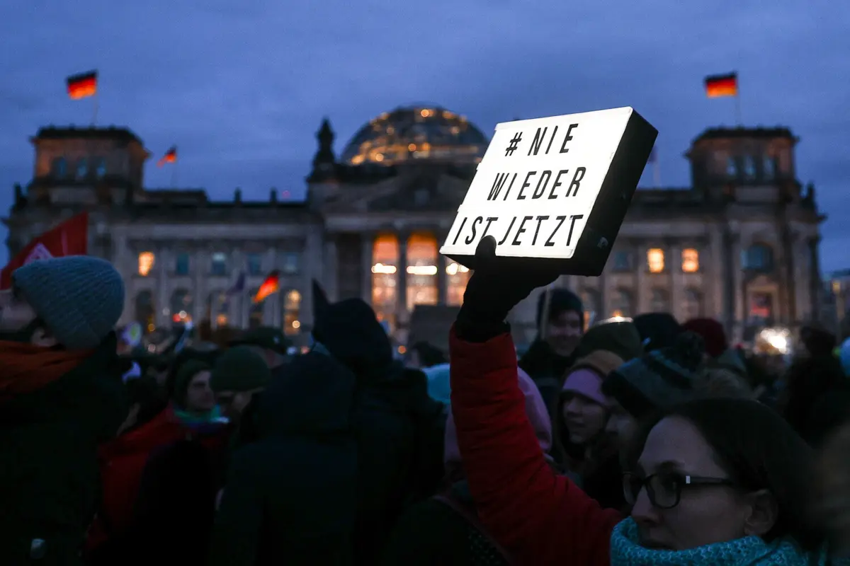 Um manifestante segura uma placa que diz "nunca mais é agora" em frente ao parlamento alemão Bundestag durante uma manifestação contra o partido de extrema-direita Alternativa para a Alemanha (AfD)