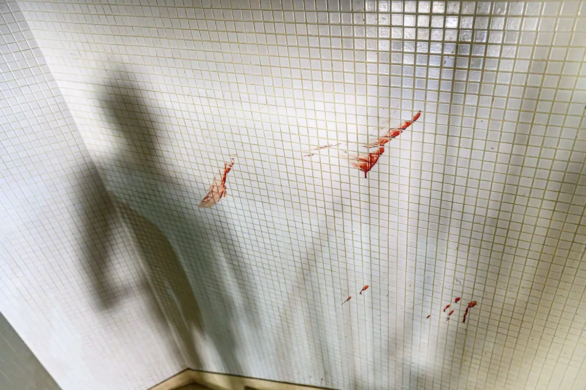 Marcas de sangue do crime eram visíveis, este domingo, nas paredes da escadaria interior do prédio