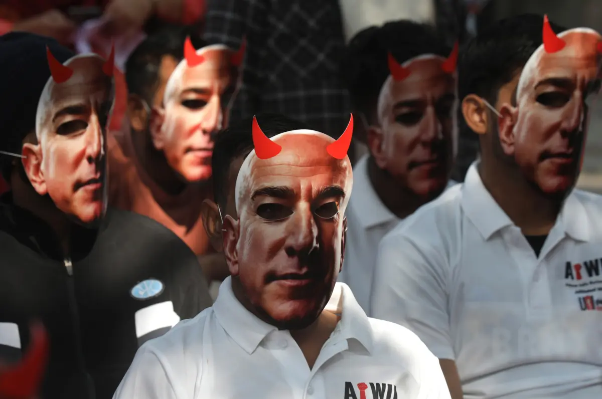 Trabalhadores da Amazon com máscaras do multimilionário Jeff Bezos, diretor-executivo da gigante tecnológica, durante um protesto laboral na Índia