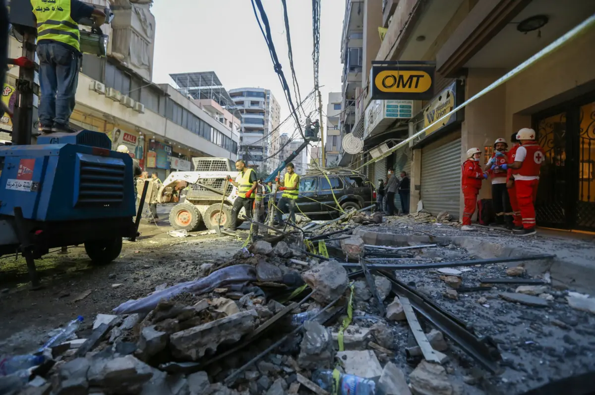 Trabalhadores limpam o local após um ataque aéreo israelita nos subúrbios do sul de Beirute