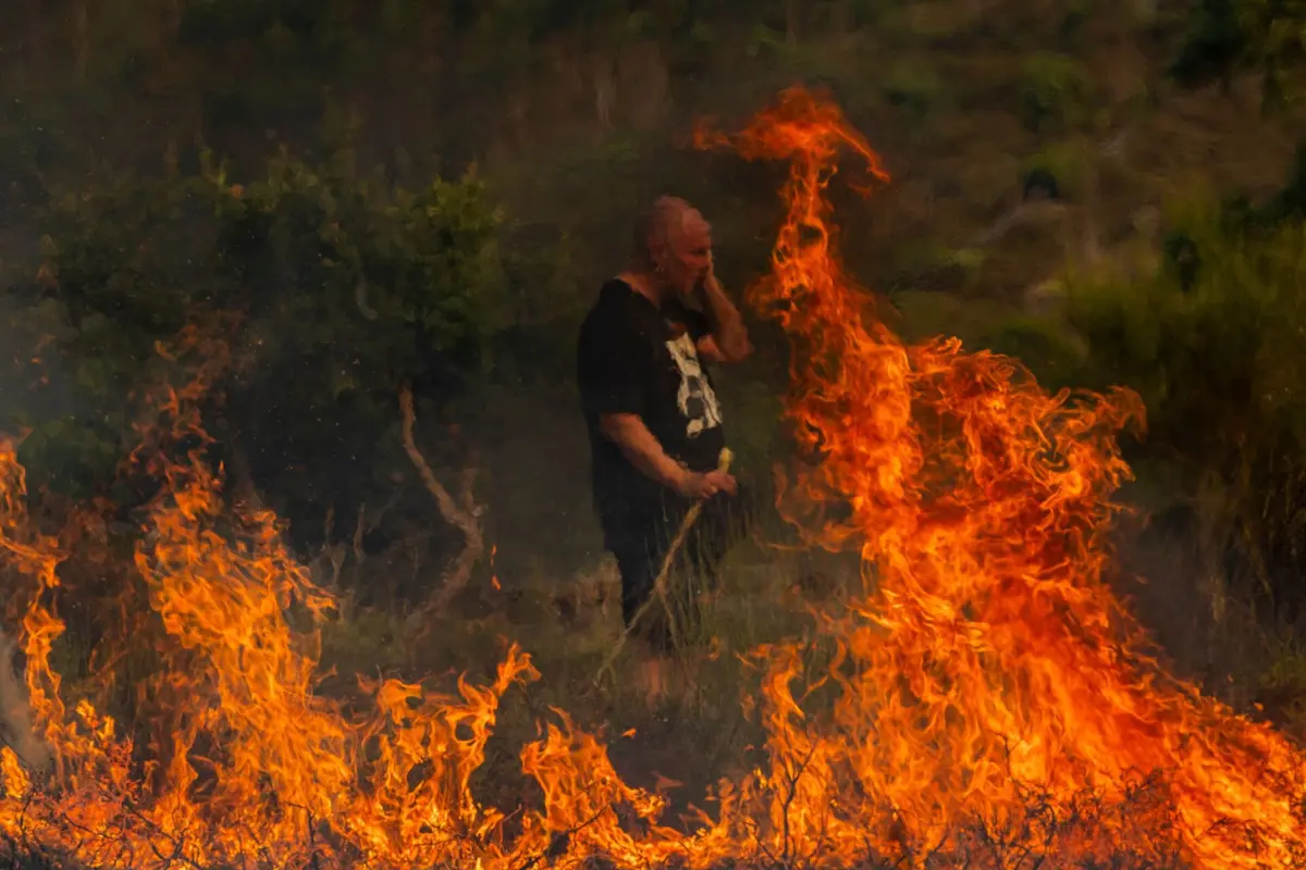 Populares e bombeiros combatem o incêndio