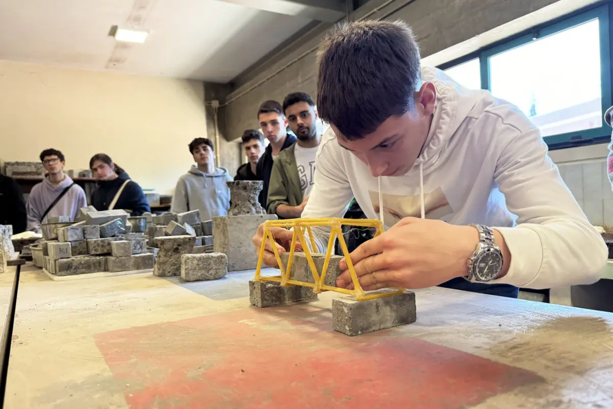 Rafael Couto coloca blocos de betão sobre a ponte de esparguete para testar a resistência