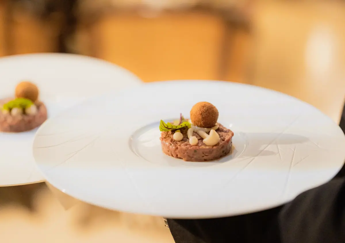 Tártaro de angus com crocante de alcatra e queijo amanteigado, picle de cogumelos, emulsão de trufa e pão de alho.