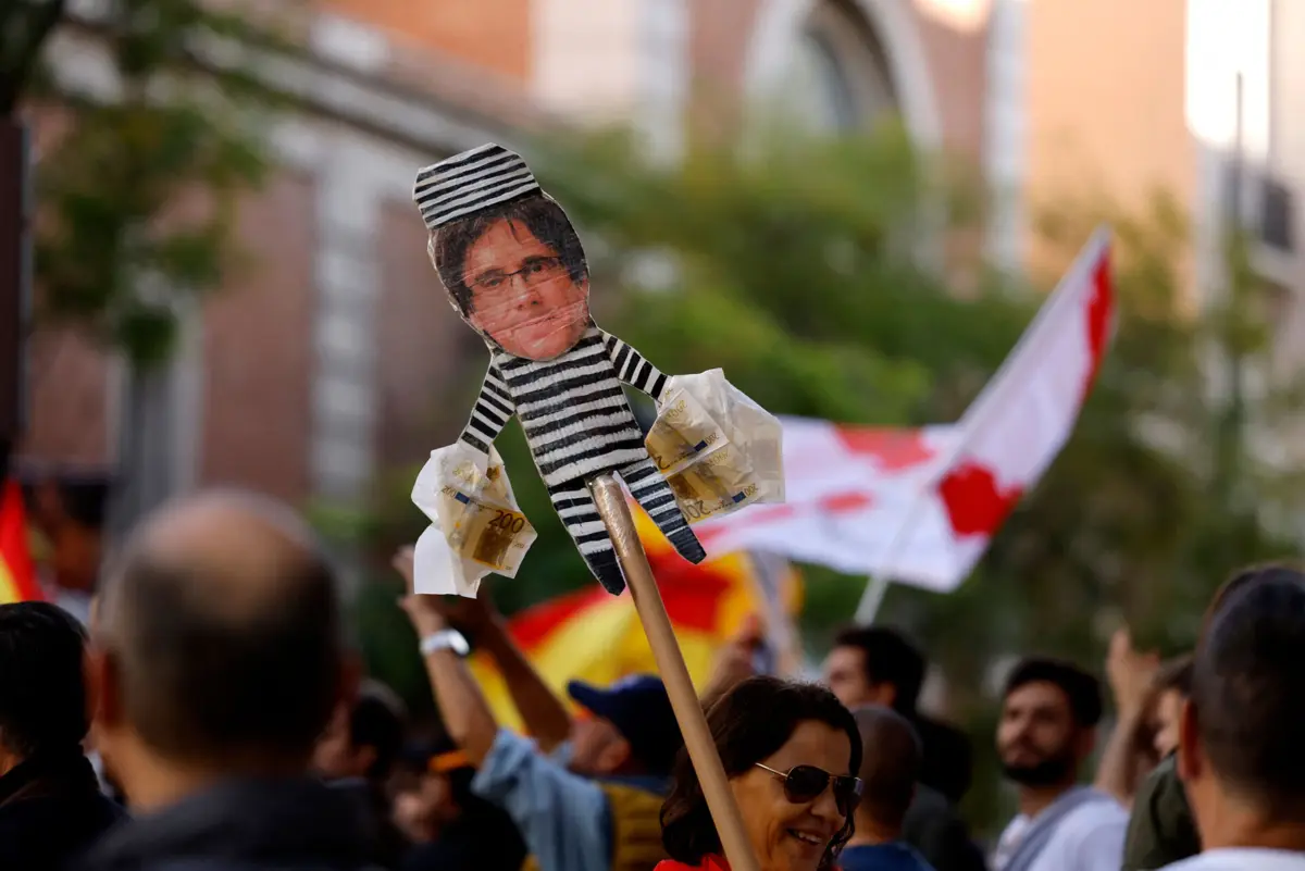 Manifestante ergue imagem do independentista Carles Puigdemont com uma roupa de recluso
