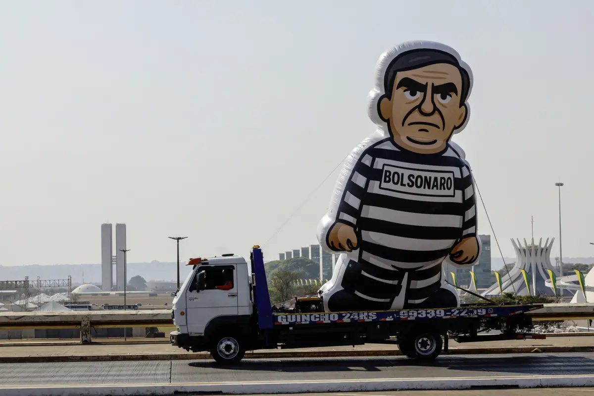 Boneco gigante insuflável de Jair Bolsonaro com roupa de recluso transportado para evento universitário em Brasília
