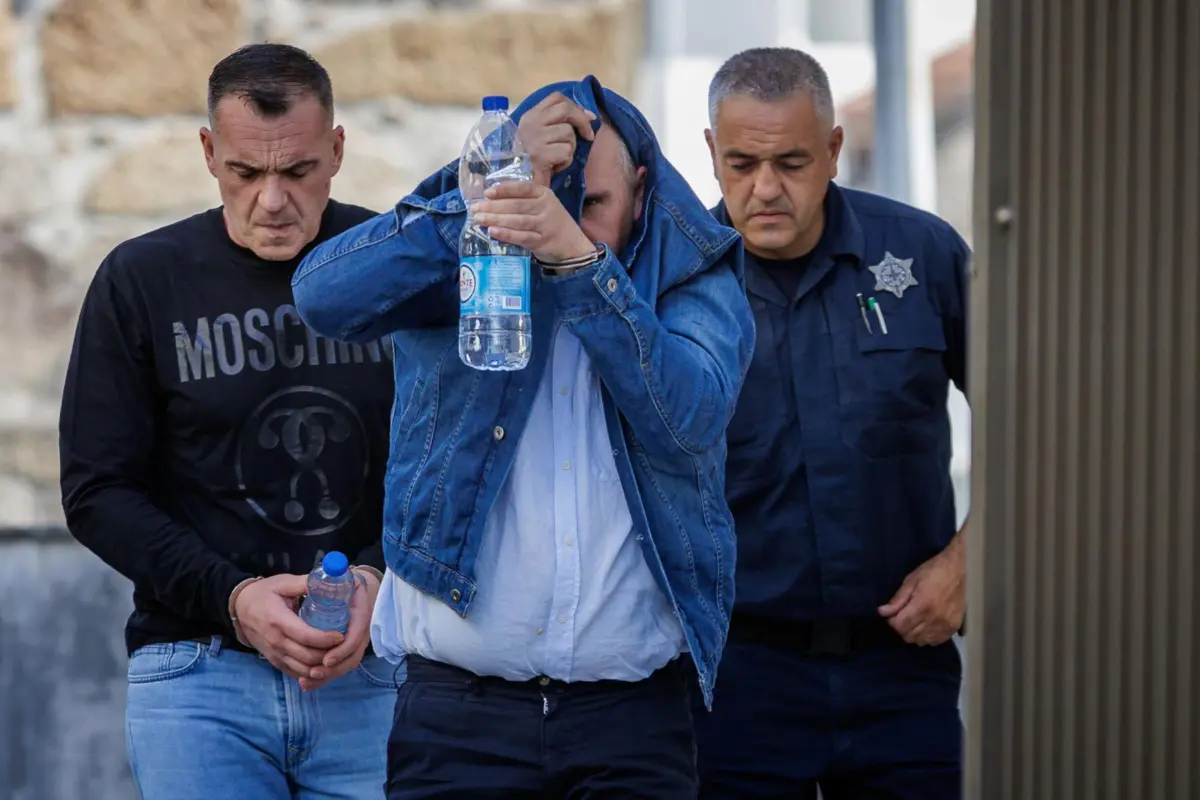 Dois dos cinco arguidos, com um guarda prisional (à dir.), à chegada ao Tribunal de Guimarães