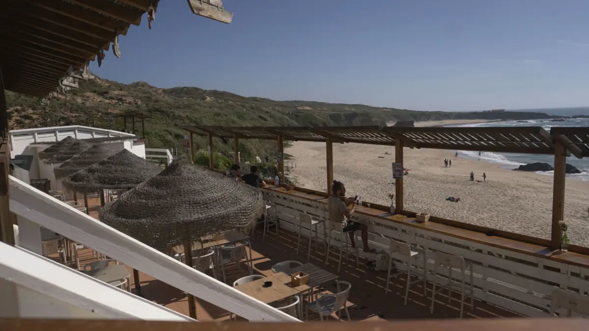 Do bar vê-se a extensão da praia e o pôr-do-sol em frente.