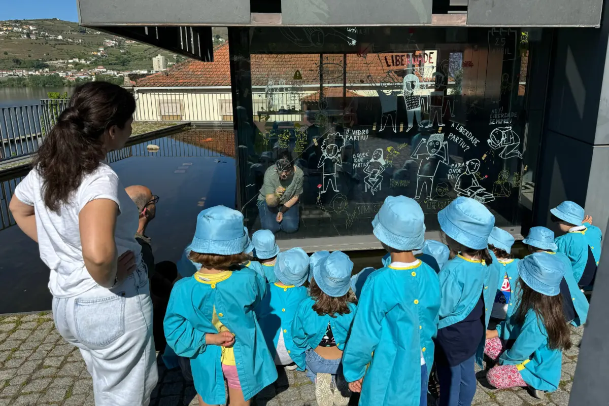 Crianças atentas ao trabalho de Sónia Borges durante ilustração sobre 25 de Abril no Museu do Douro
