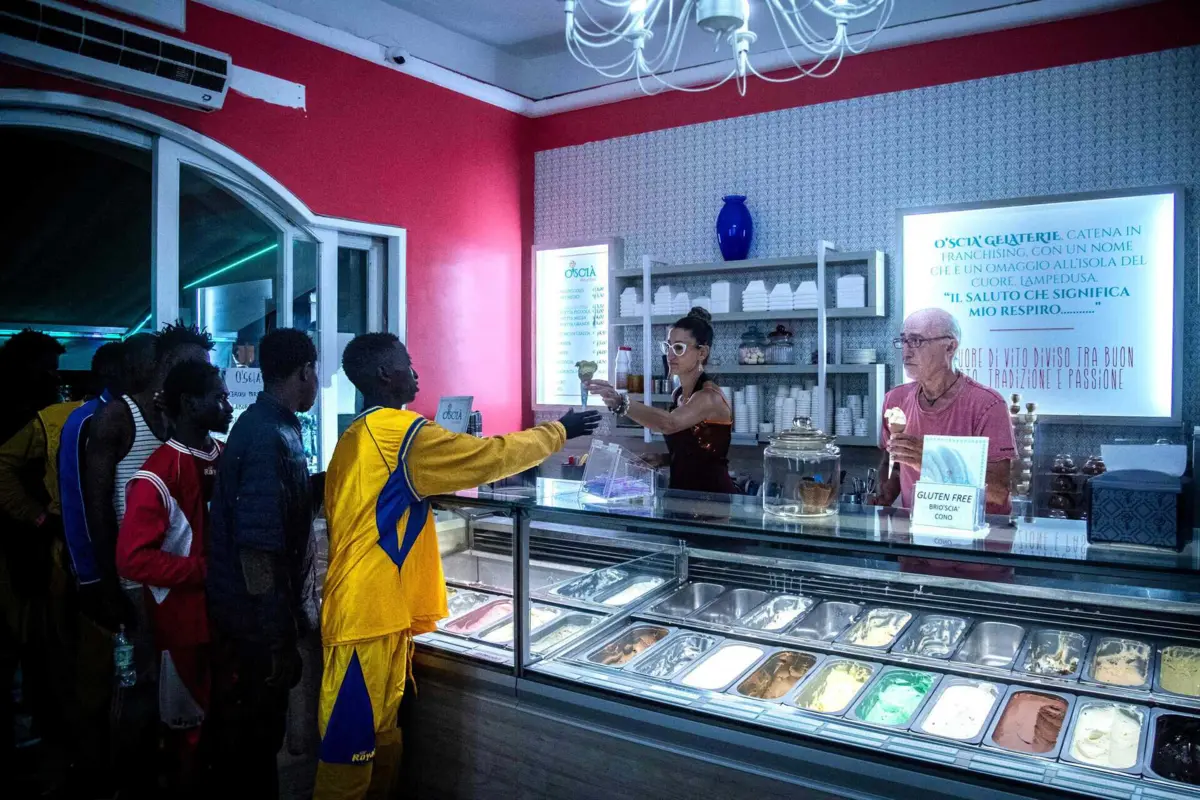 Vendedor oferce gelados a migrantes retidos na ilha italiana de Lampedusa