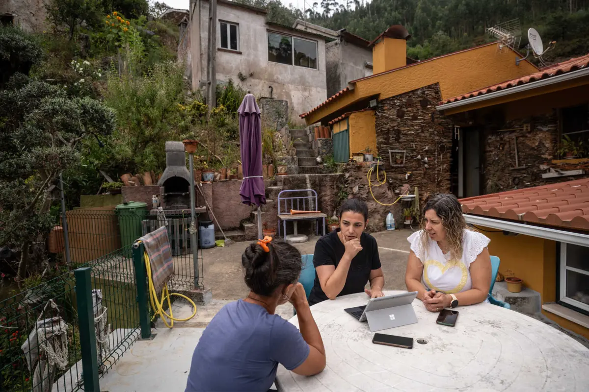 Andreia e Ana olham para um computador no pátio de Patrícia Matos