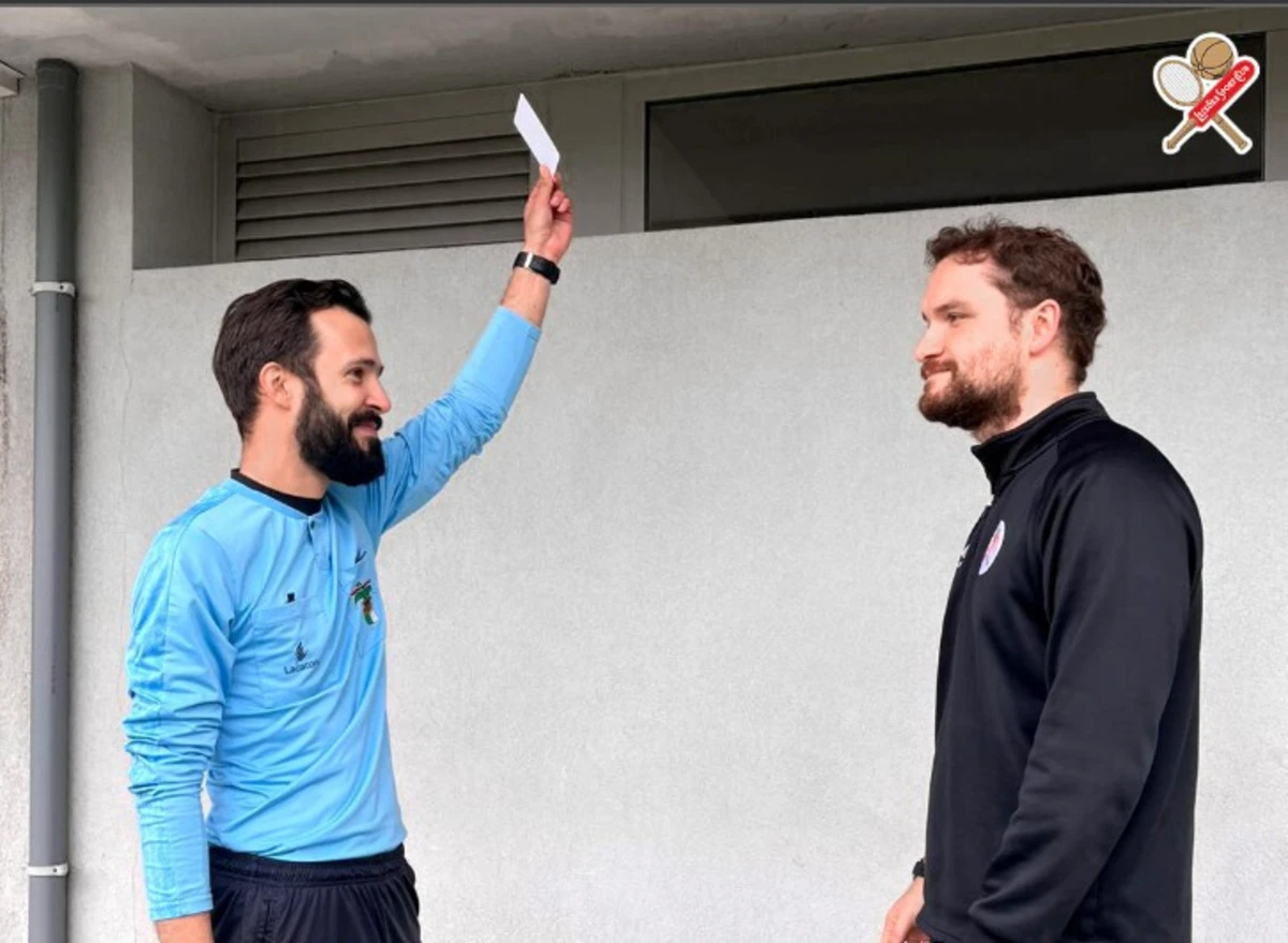 Edgar Castro, jovem árbitro da A. F. Porto, mostra o cartão branco a Henrique Lemos, treinador dos sub-11 do Leixões