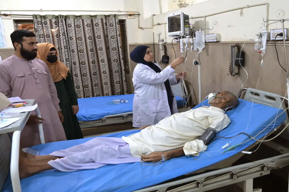 Enfermeira cuida de um doente em Lahore, no Paquistão