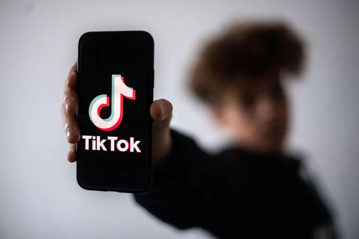(FILES) A teenager presents a smartphone with the logo of Chinese social network Tik Tok, on January 21, 2021 in Nantes, western France. On September 11, 2025, a parliamentary commission of inquiry will present its report on the psychological effects of TikTok on minors to the National Assembly. (Photo by LOIC VENANCE / AFP)