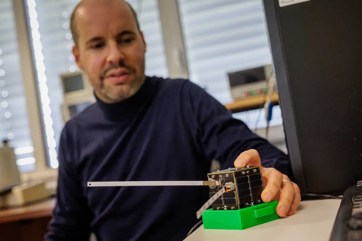 O investigador Alexandre Ferreira da Silva mostra o satélite Prometheus-1, que pesa 250 gramas