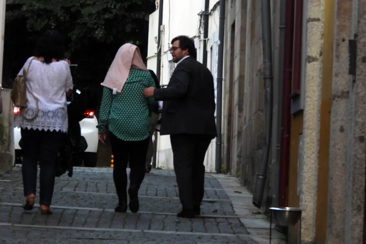 A mãe da criança, ao centro, com o advogado João Araújo Silva e a técnica da segurança social
