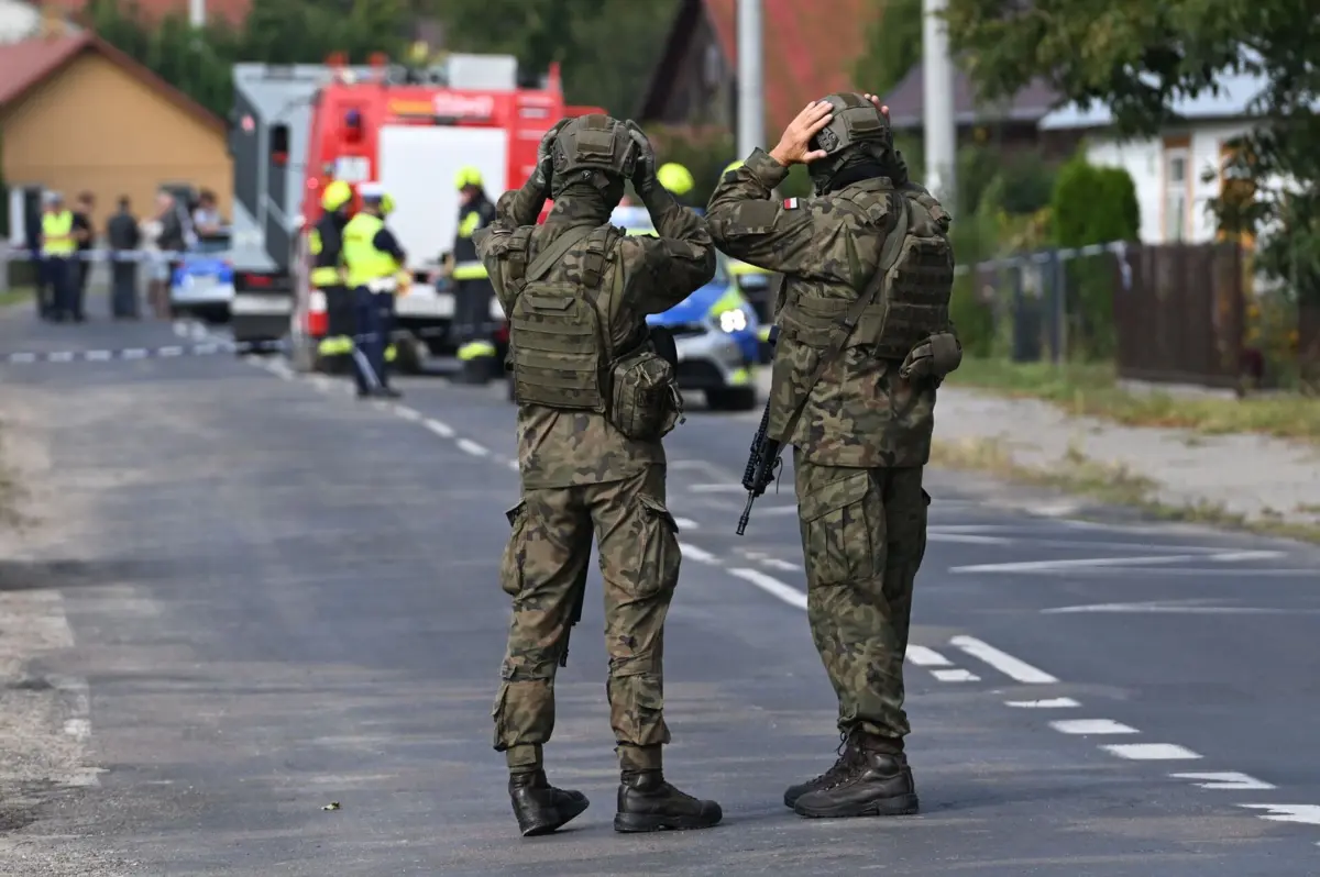 Militares e serviços de socorro em Wyryki, onde drone russo causou danos no telhado de uma habitação