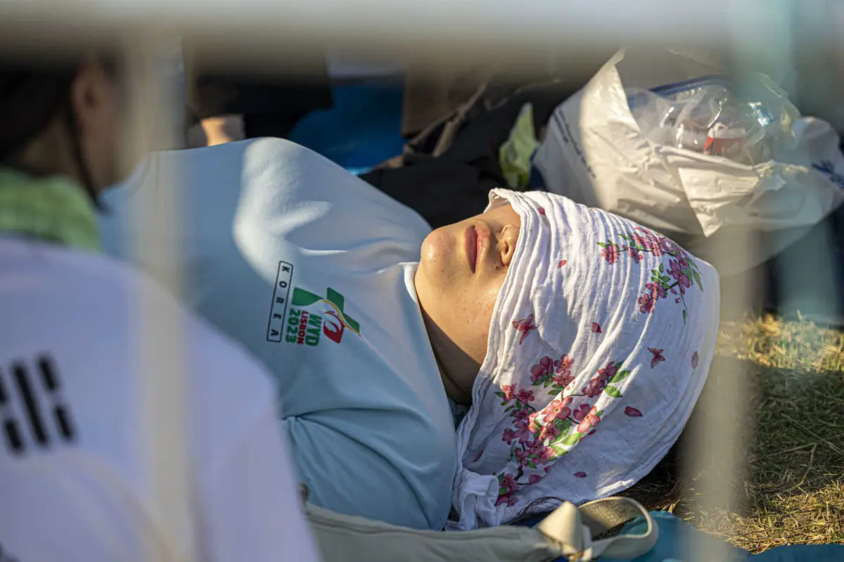 Os jovens improvisam sombras para se protegerem do calor