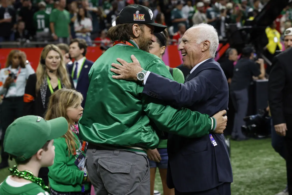 Bradley Cooper com Jeffrey Lurie, o proprietário proprietário do Philadelphia Eagles, e a filha ao lado