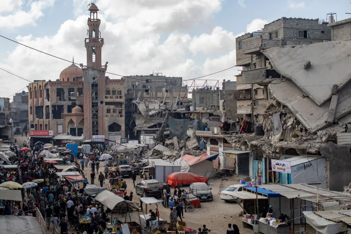 Palestinianos num mercado dentro do campo de refugiados de Khan Younis