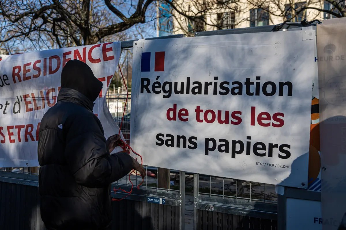 Protesto com um cartaz a pedir a regularização de todos os imigrantes indocumentados