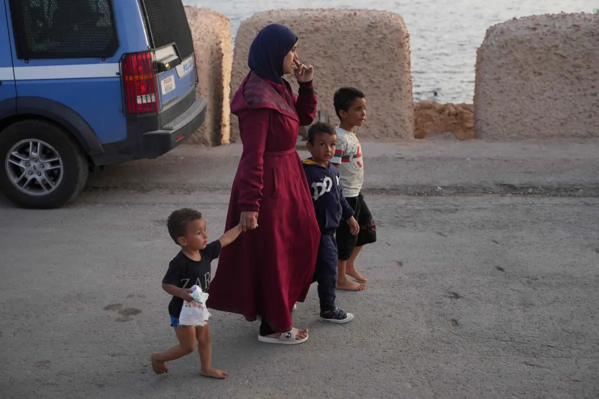 Uma família de migrantes anda nas ruas na ilha de Lampedusa, em Itália