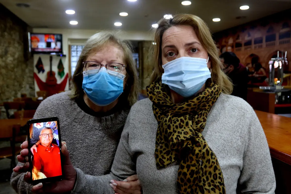 Renata Martins, com a mãe e uma foto do falecido pai
