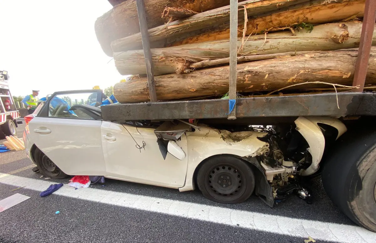 Automóvel da vítima ficou enfaixado por baixo de um camião carregado de lenha