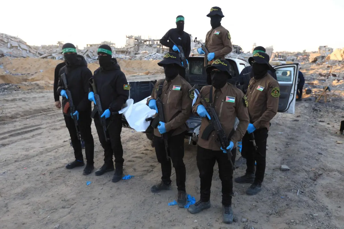 Militantes da Jihad Islâmica e do Hamas transportam um saco branco para cadáveres, que se acredita conter os restos mortais de um refém israelita, na cidade de Beit Lahia, no norte da Faixa de Gaza.