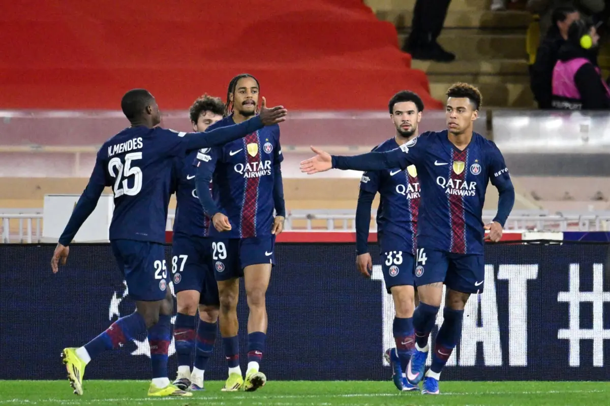 Paris Saint-Germain's French midfielder #14 Desire Doue (R) celebrates with teammates after scoring his team's third goal during the UEFA Champions League knockout round play-off first leg football match between AS Monaco and Paris Saint-Germain at the Stade Louis II in the Principality of Monaco on February 17, 2026. (Photo by FREDERIC DIDES / AFP)