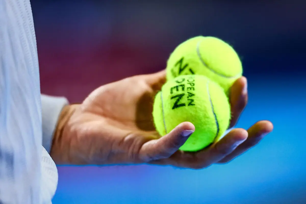 An official holds tennis balls during the European Open ATP tennis tournament in Brussels, on October 16, 2025. (Photo by DAVID PINTENS / Belga / AFP) / Belgium OUT