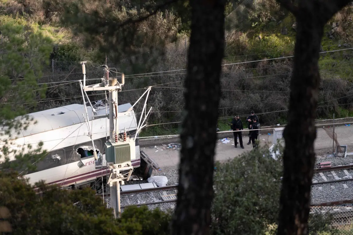 Spain's Guardia Civil agents work at the site of an Iryo train that derailed and was hit by another train the day before, killing at least 39 people and injuring more than 120, in Adamuz, southern Spain, on January 19, 2026. At least 39 people died and more than 120 injured in the deadliest train accident in Spain in over a decade. The crash happened on January 18, 2026 evening when a train operated by rail company Iryo travelling from Malaga to Madrid derailed near Adamuz, crossing onto the other track where it crashed into an oncoming train, which also derailed. (Photo by JORGE GUERRERO / AFP)