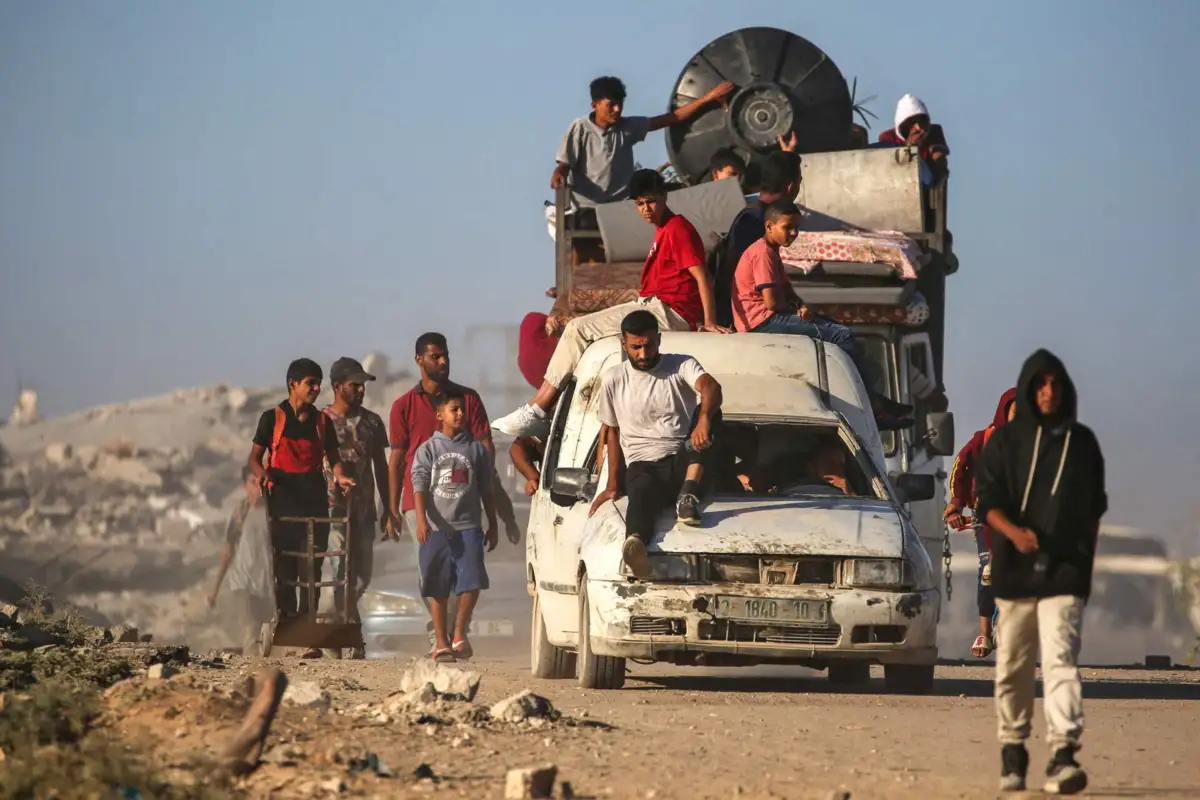 Palestinians make their way to Gaza City from through the so-called "Netzarim corridor" from Nuseirat in the central Gaza Strip on October 11, 2025. Israel declared a ceasefire in Gaza and began to pull back its forces on October 10, as tens of thousands of exhausted Palestinians made their way back to their devastated homes. (Photo by Eyad BABA / AFP)