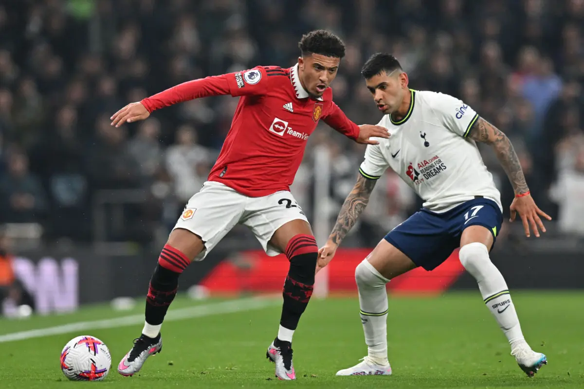 Jadon Sancho num duelo com o argentino
Cristian Romero, do Tottenham (Créditos: Glyn Kirk / AFP)