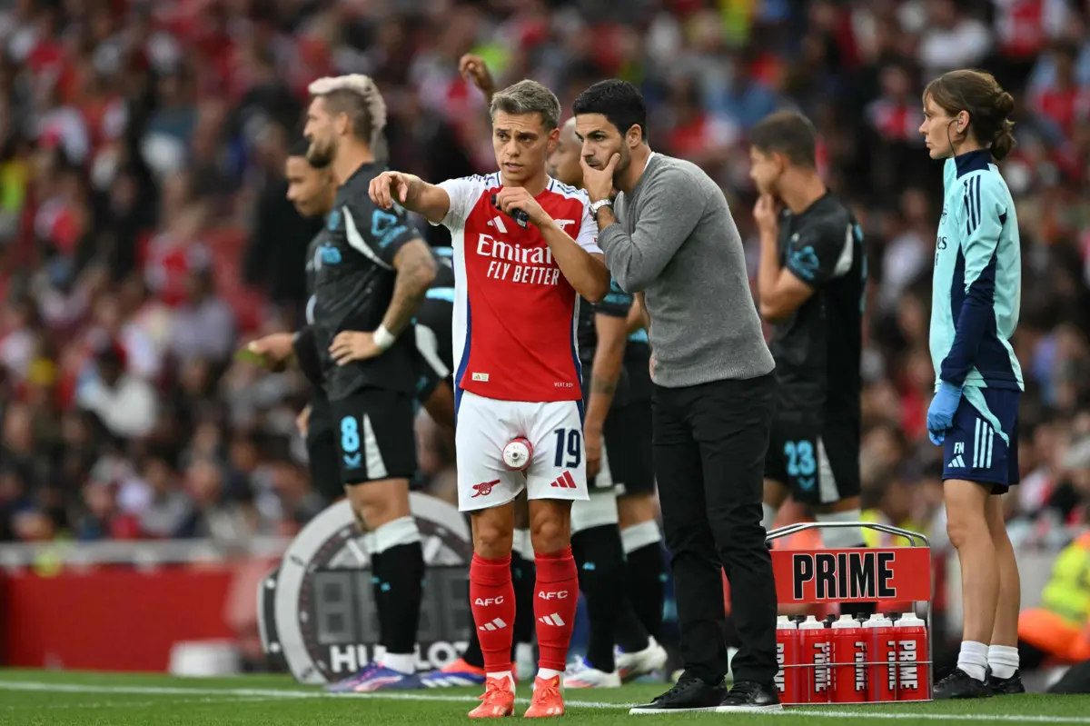Leandro Trossard com o treinador Mikel Arteta (Créditos: AFP)