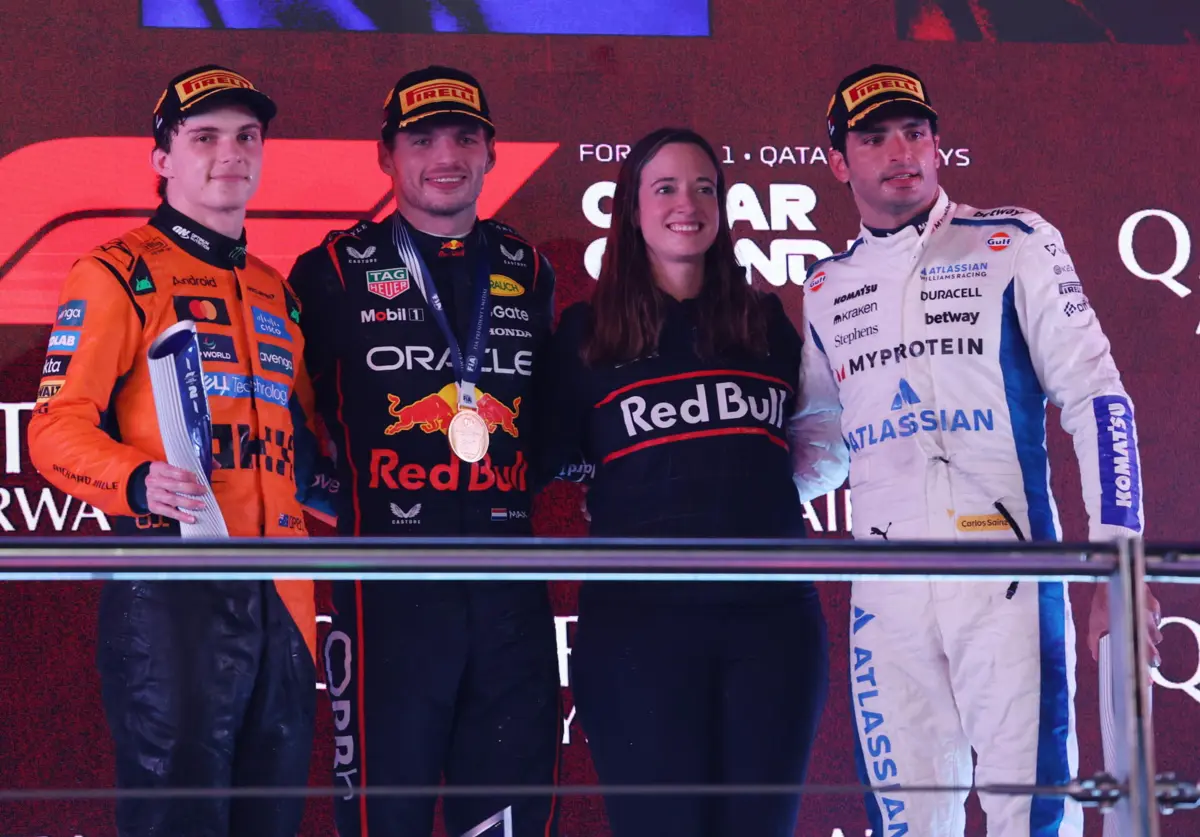 Max Verstappen e Hannah Schmitz no pódio, entre Oscar Piastri e Carlos Sainz