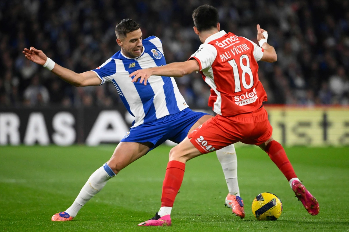 FC Porto's Polish defender #05 Jan Bednarek and Sporting Braga's Spanish forward #18 Pau Victor Delgado fight for the ball during the Portuguese League football match between FC Porto and SC Braga at Dragao stadium in Porto on November 2, 2025. (Photo by Miguel RIOPA / AFP)